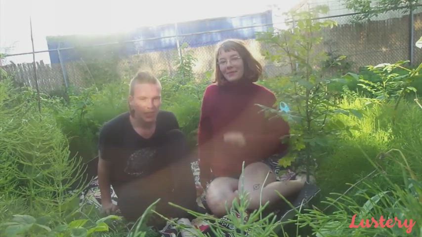 Joy &amp; Mark touch grass, while touching each other.
