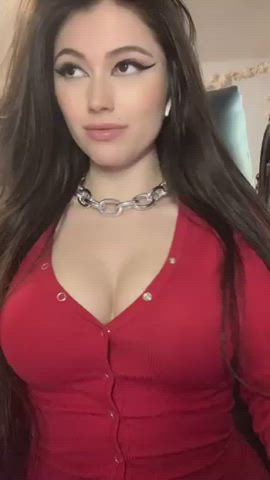 This brunette is wearing a red snap button bodysuit with winged eyeliner and a link